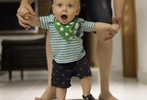 Papa ayudando a su hijo a caminar