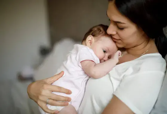 Mamá sosteniendo su bebe en brazos