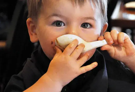 Niño tomando sopa con una cuchara