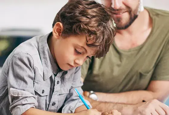 Niño realizando su tarea con su padre