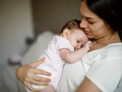 Mamá sosteniendo su bebe en brazos