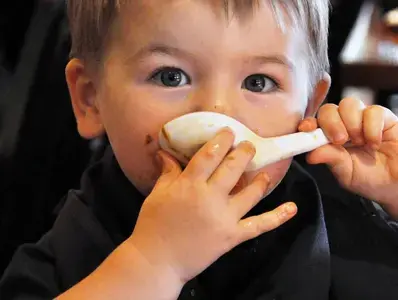 Niño tomando sopa con una cuchara