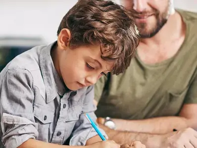 Niño realizando su tarea con su padre