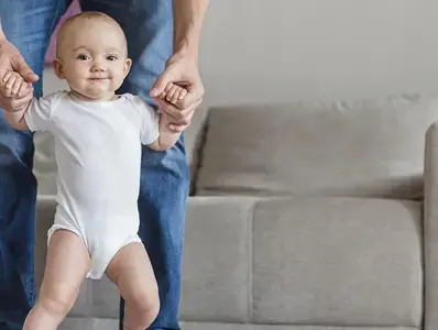 Papa enseñando a caminar a su hija