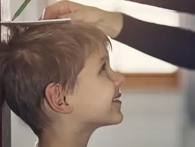 Adulto tomando nota de la altura de un niño